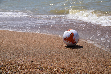 a soccer ball floats near the shore in the sea