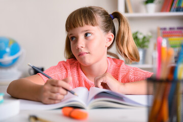 Tired girl studying school assignments at home