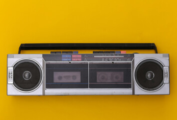 80s Retro Outdated Portable Stereo Radio Cassette Recorder on Yellow Background. Top view