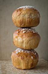 Three homemade sweet petite brioche buns with pearl sugar isolated on a kitchen's old table - food...