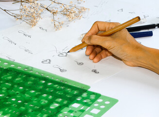 Designers are painting a jewelry pendant on paper.