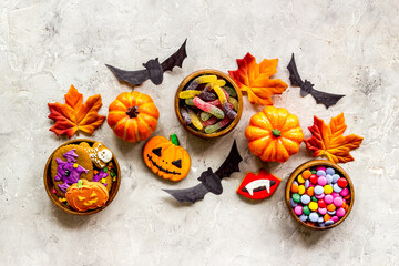 Halloween holiday background with pumpkins, cookies and autumn leaves, top view