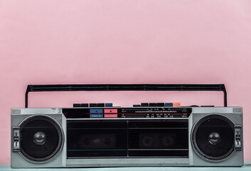 80s Retro outdated portable stereo radio cassette Recorder on pink pastel background.