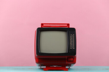 Red retro old portable mini tv set on pink blue pastel  background.