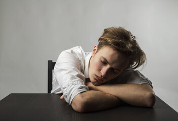 Tired young man. Overtime and fatigue concept.