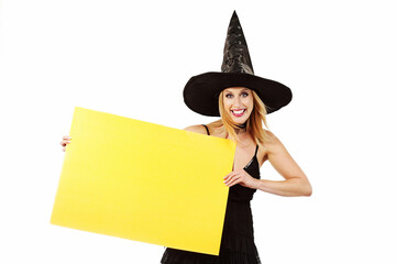 jeune et jolie femme blonde souriante déguisée en sorcière d'Halloween sexy avec un chapeau pointu sur fond isolé blanc de studio 