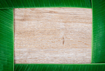 Blank wooden background with banana green leaves.