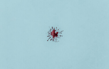 Drop of blood on a blue background.