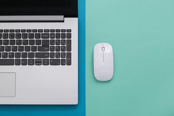 Laptop with pc mouse on a colored paper background. Online workspace. Remote work. Studio shot. Top view. Flat lay