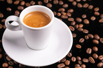 Mugful of coffee in white cup and saucer with coffee grains background