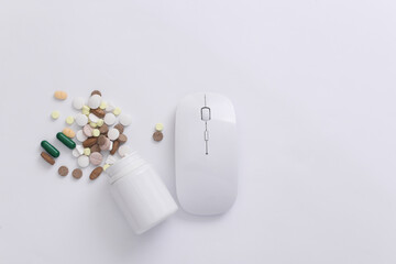 Pc mouse with bottle pills on white background. Top view. Flat lay
