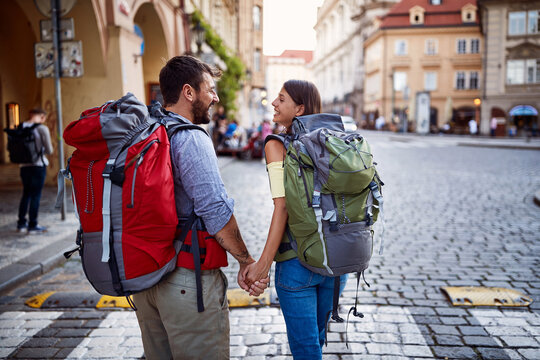 Walking at European street at vacation.Man and woman with backpack in love traveling together.