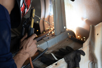 Worker,welding in a car factory with sparks, manufacturing, industry