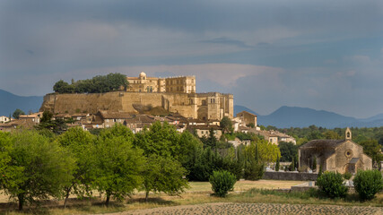 Obraz premium View of the castle of Grignan in Provence under a busy sky