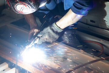 Worker,welding in a car factory with sparks, manufacturing, industry