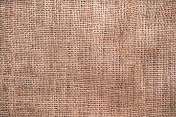 A closeup top view of natural hessian material texture background fabric.