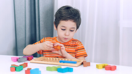 toddler boy playing indoors with educational toy.