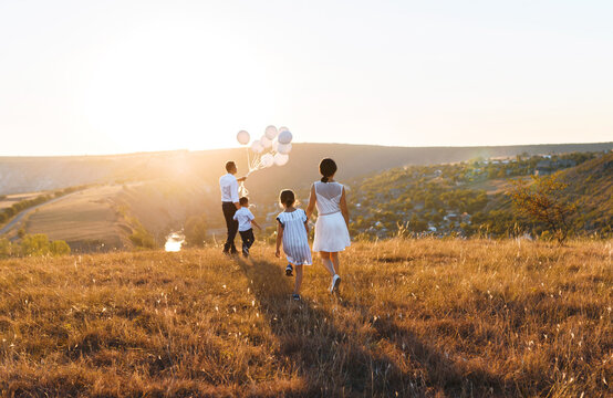 walking family with balloons watching landscape