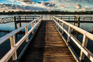 Fototapeta premium Wooden Jetty into the distance over water at sunrise