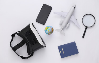 Virtual travel. Virtual reality headset with globe, passport, smartphone and plane on white background. Top view