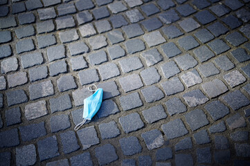 Used, dirty and old face medical mask, used for the anti corona virus, lies on the street like a...