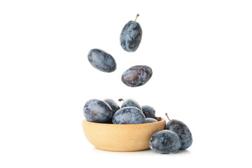 Falling plums and bowl with plums isolated on white background