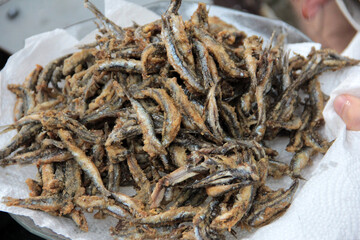 Anchovies are fried in vegetable oil in a pan.