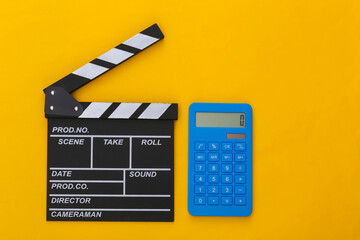 Fototapeta na wymiar Movie clapper board and calculator on yellow background. Cinema fees. Filmmaking, Movie production. Top view