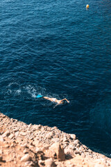 Obraz premium A woman enjoys a swim in crystal clear waters while wearing fins
