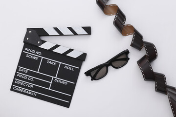 Movie clapper board with film tape, 3d glasses on white background. Filmmaking, Movie production,...