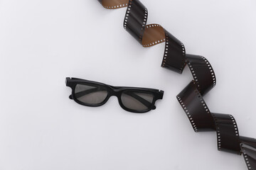 Film tape and 3d glasses on white background. Сinema, Entertainment industry. Top view