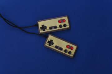 Retro gamepads on classic blue background. Retro gaming. Color 2020. Top view.