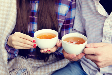 Fototapeta na wymiar Young man and woman holding a cup of tea