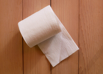Simple toilet paper on wood background.