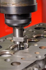 A machine for grinding car valves is being set up in the workshop.