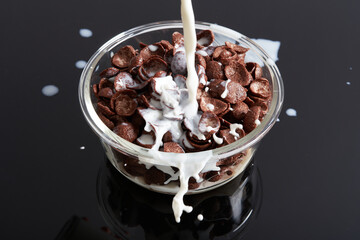 Chocolate Cereals Milk Pouring in Black Background