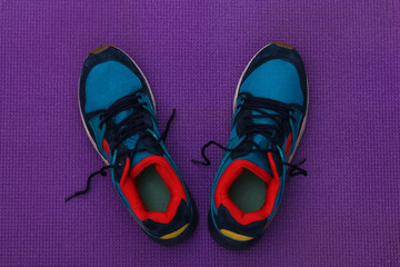 Running shoes on purple background. Top view