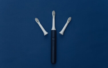 Electro toothbrush with replaceable heads on classic blue background. Color 2020. Top view