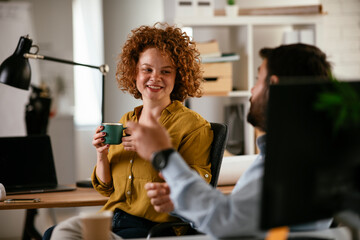 Colleagues in office. Businesswoman and businessman discussing work while drinking coffee..