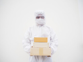 Young man in PPE suite uniform while holding cardboard boxes in medical rubber gloves and mask. coronavirus or COVID-19 concept isolated white background