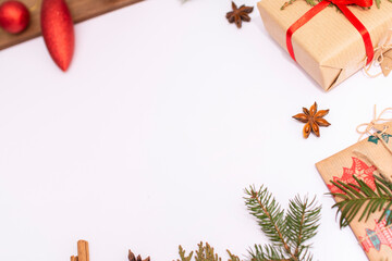 Gifts, Christmas tree branches, christmas toys and cones lie on a white background. Flat lay
