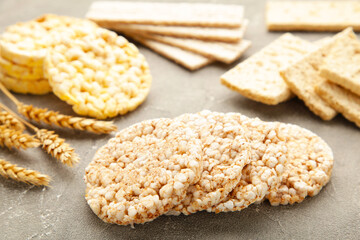 Different types of crispbread on grey background.