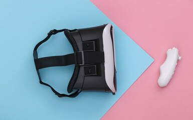 Virtual reality headset with joystick on pink blue pastel background. Top view. Flay lay. Minimalism