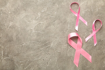 Pink ribbons symbol of breast cancer on grey background. Empty space for text