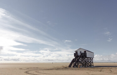 Wood on stilts on the beach of Sankt Peter-Ording on the North Sea in pastel tones