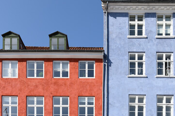 Fototapeta na wymiar Colorful houses in red and blue of the Nyhaven in Copenhagen Denmark photographed frontally on a sunny day with a bright blue sky.
