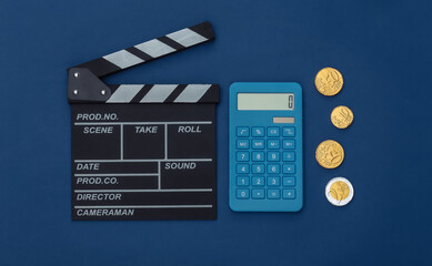 Fototapeta na wymiar Movie clapper board and coins, calculator on classic blue background. Cinema fees. Filmmaking, Movie production. Top view