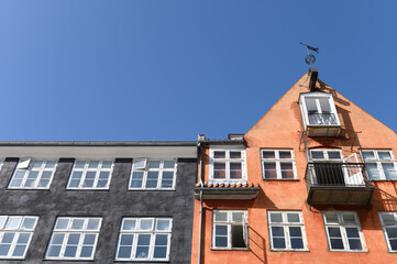 Fototapeta na wymiar Colorful houses in black and orange of the Nyhaven in Copenhagen Denmark on a sunny day with a bright blue sky.