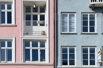 Fototapeta premium Colorful houses in pink and blue of the Nyhaven in Copenhagen Denmark photographed frontally on a sunny day with a bright blue sky.