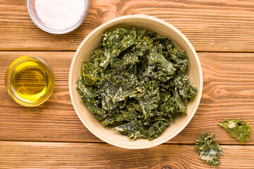 Kale chips on wooden background close-up, top view